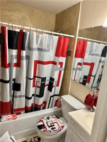 Bathroom featuring vanity and shower / bath combination with curtain