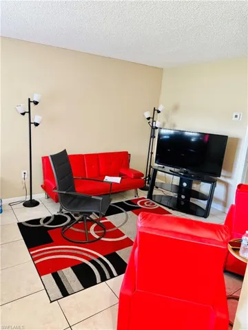 Living area featuring tile patterned flooring and a textured ceiling