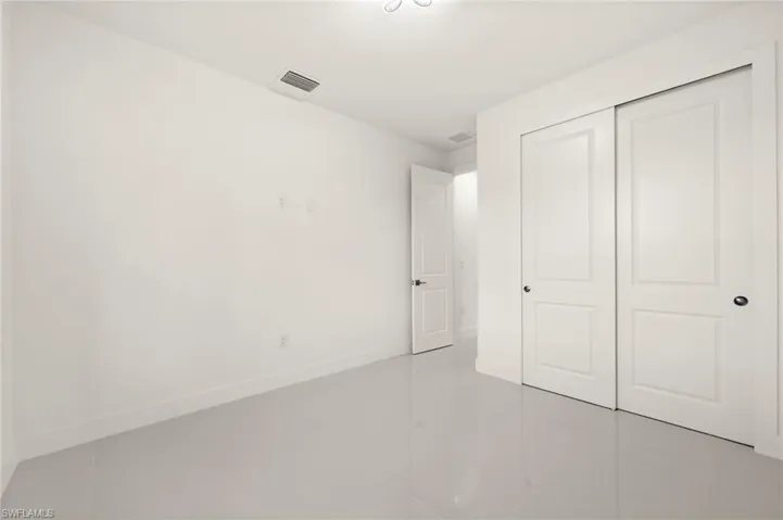 Unfurnished bedroom with a closet and light tile patterned flooring
