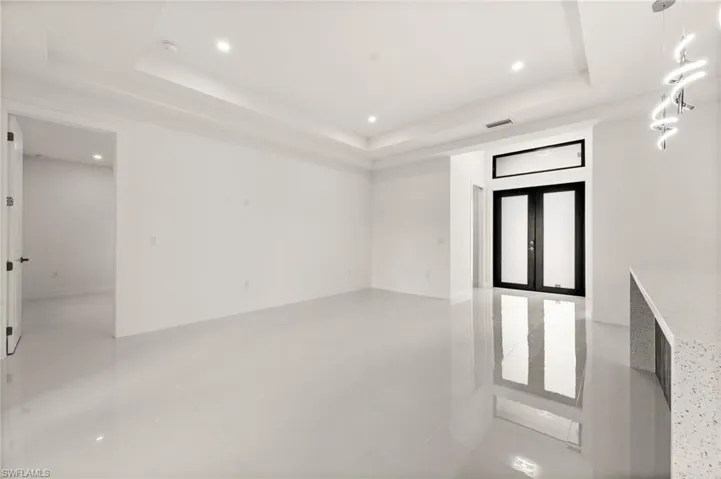 Empty room featuring recessed lighting, a tray ceiling, and light tile patterned flooring