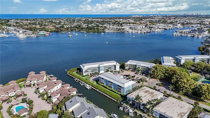 Aerial view showcasing the property's waterfront location, with canals, boat docks, and views of the wider waterway and coastline