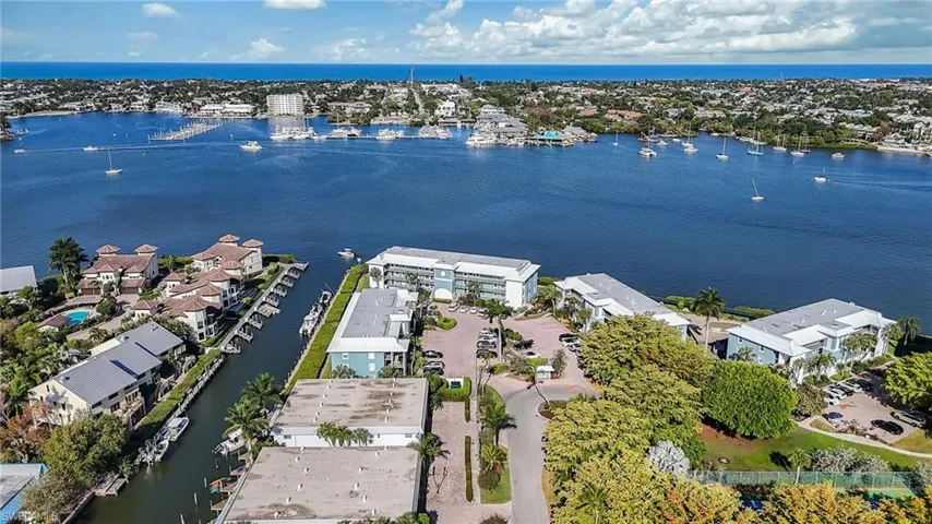 An aerial view showcasing the property's waterfront location, with views of the bay and the distant ocean