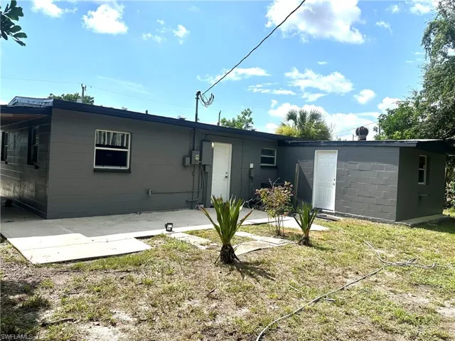 Rear view of house featuring a patio and concrete block siding
