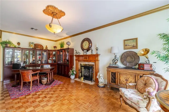 Dining space with ornamental molding and a tiled fireplace