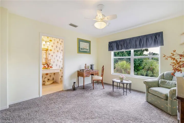 Living area featuring carpet floors and a ceiling fan