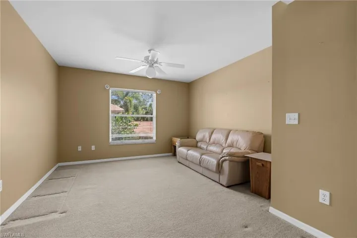 Neutral-toned walls and light-colored carpeting define this spacious room