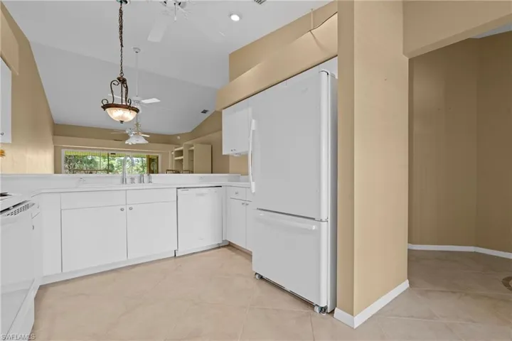 Kitchen featuring white cabinetry, a refrigerator, and a dishwasher