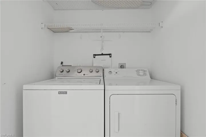 Dedicated laundry area featuring a white top-load washing machine and front-load dryer