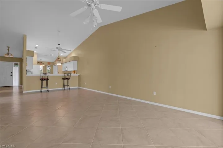 Spacious interior with tile flooring and vaulted ceilings