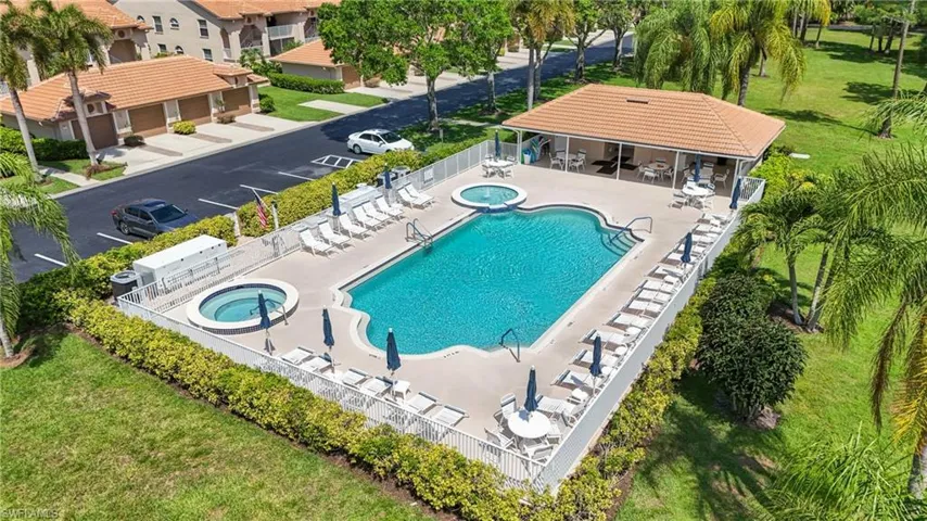 Resort-style pool area featuring a freeform swimming pool, two integrated spas, and an adjacent covered cabana