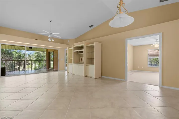 Expansive living area with tile flooring and a vaulted ceiling