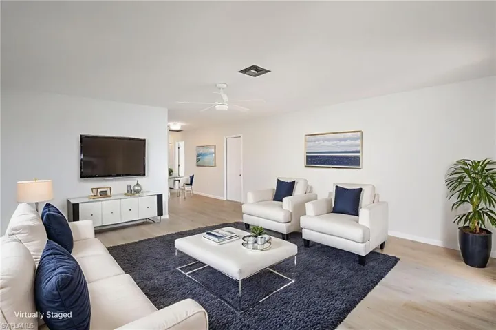 Living area with light wood-type flooring and new light/ceiling fan