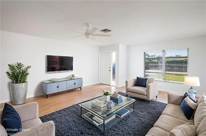Living room with light wood-style floors and new light/ceiling fan