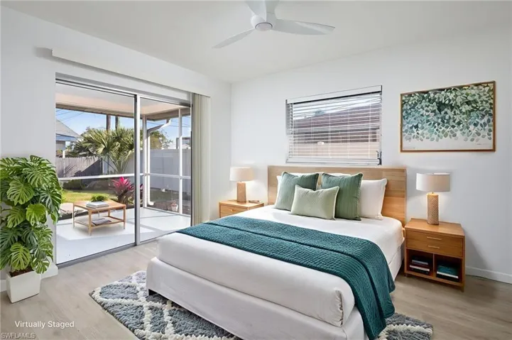 Bedroom featuring access to exterior spacious lanai, light wood-type flooring, and new ceiling fan/light.