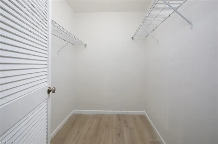Primary Walk in closet with light wood-type flooring