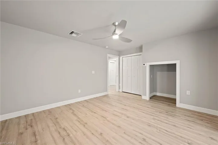 Unfurnished bedroom with ceiling fan and light hardwood / wood-style flooring