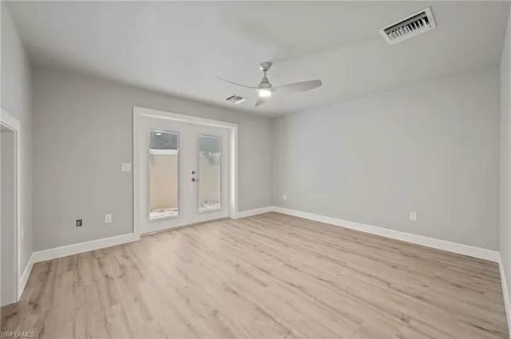 Spare room featuring french doors, ceiling fan, and light hardwood / wood-style floors