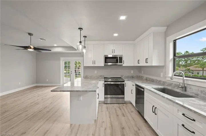 Kitchen featuring sink, ceiling fan, stainless steel appliances, and light hardwood / wood-style floors
