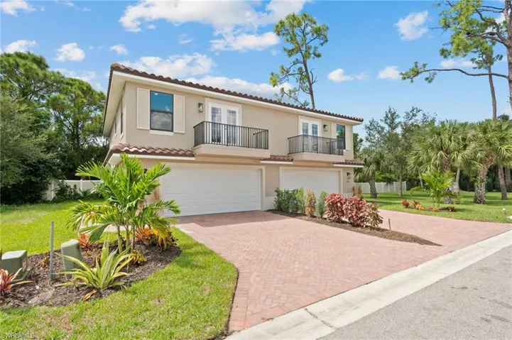 Mediterranean / spanish house featuring a balcony, a garage, and a front lawn