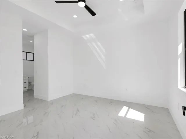 Empty room featuring light marble finish floors, recessed lighting, and ceiling fan