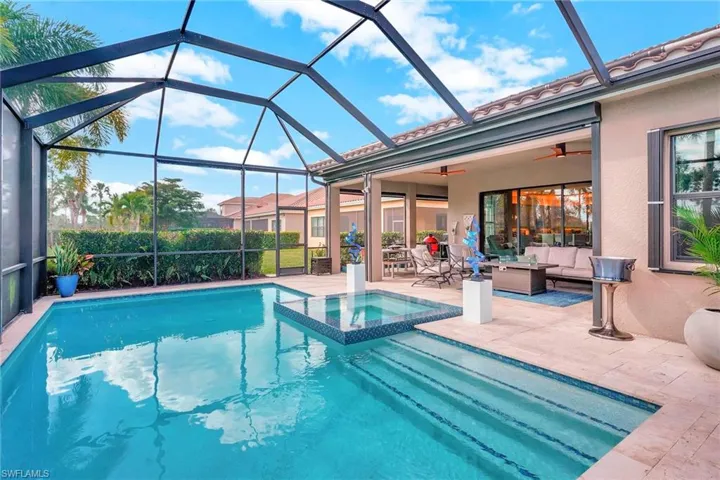 View of swimming pool featuring glass enclosure, an in ground hot tub, a patio, ceiling fan, and an outdoor living space