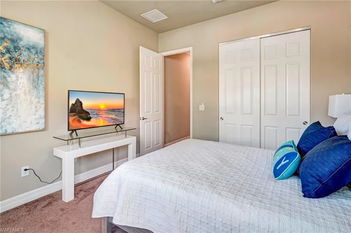 Carpeted bedroom featuring a closet