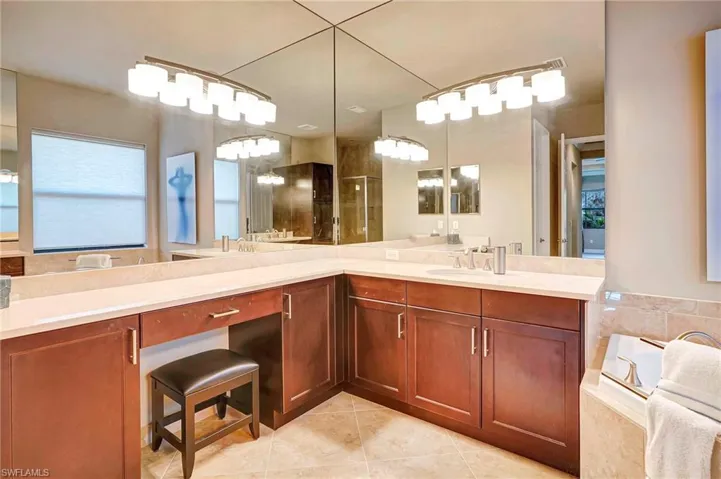 Bathroom featuring tile patterned floors, tiled bath, and vanity
