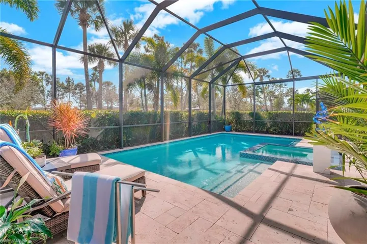 View of pool with an in ground hot tub, a lanai, and a patio area