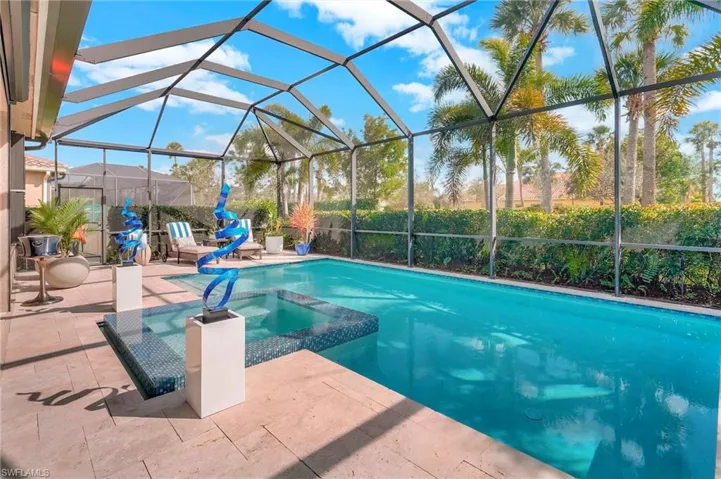 View of swimming pool with an in ground hot tub, a patio, and a lanai