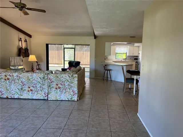 Living room with tile patterned floors and ceiling fan