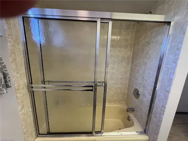 Bathroom with combined bath / shower with glass door