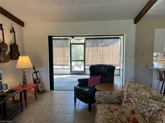 Living room featuring beamed ceiling and light tile patterned floors