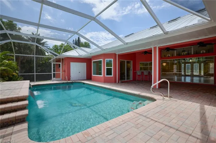 Swimming pool with a patio, a ceiling fan, and a lanai