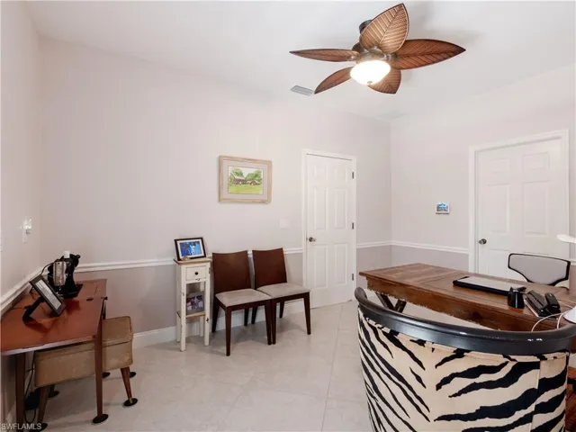 Office space with light tile patterned floors and ceiling fan