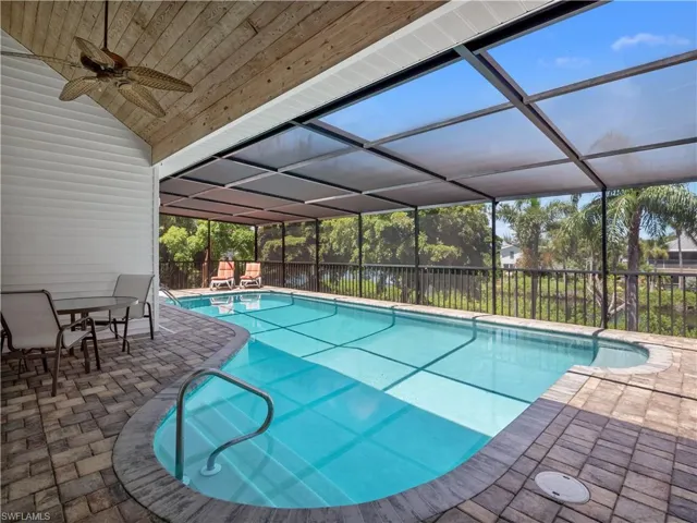 View of pool featuring ceiling fan, a patio area, and a lanai