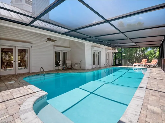 View of swimming pool featuring french doors, glass enclosure, a patio area, and ceiling fan