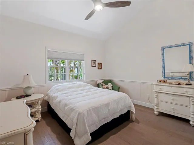 Bedroom with vaulted ceiling, ceiling fan, and hardwood / wood-style floors