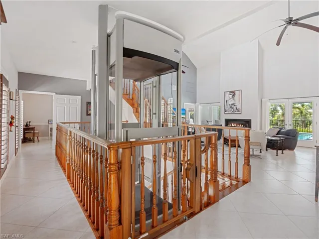 Corridor featuring light tile patterned flooring, vaulted ceiling, and french doors