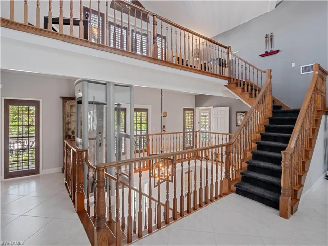 Staircase featuring light tile patterned flooring and a high ceiling