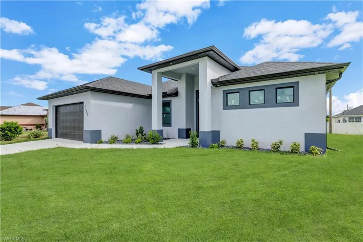 Prairie-style home featuring a garage and a front lawn