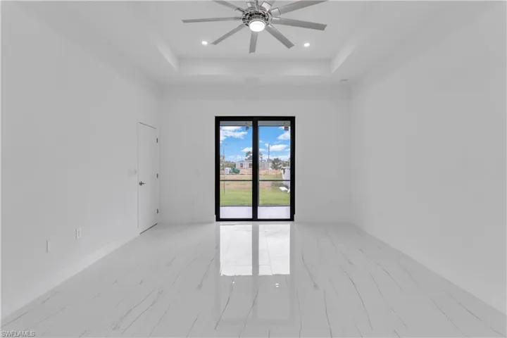 Spare room featuring ceiling fan and a tray ceiling
