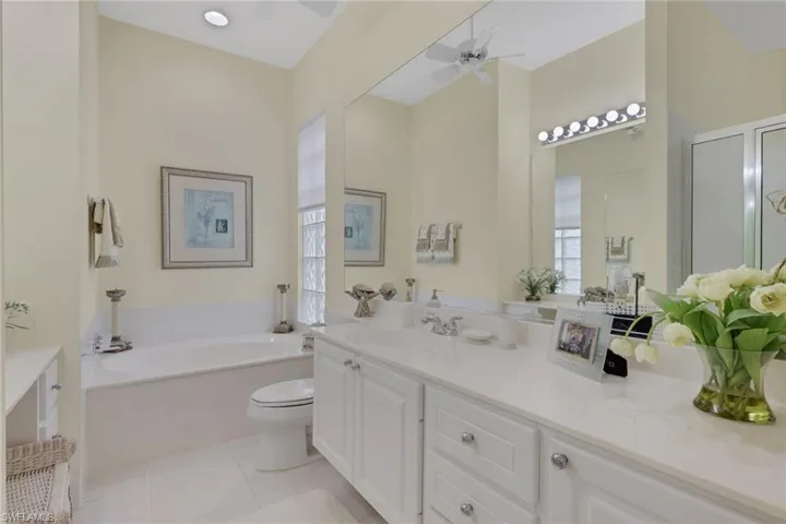 Full bathroom with a garden tub, vanity, light tile patterned floors, a ceiling fan, and an enclosed shower
