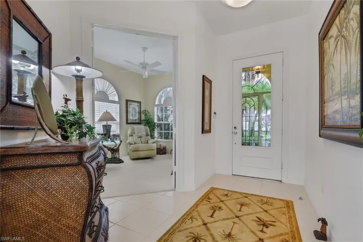 Foyer entrance with light tile patterned floors and a ceiling fan