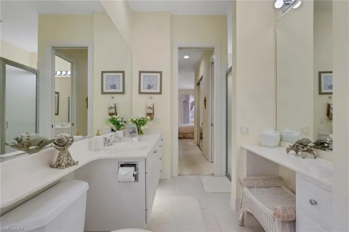 Full bath featuring vanity, ensuite bathroom, light tile patterned flooring, light carpet, and an enclosed shower