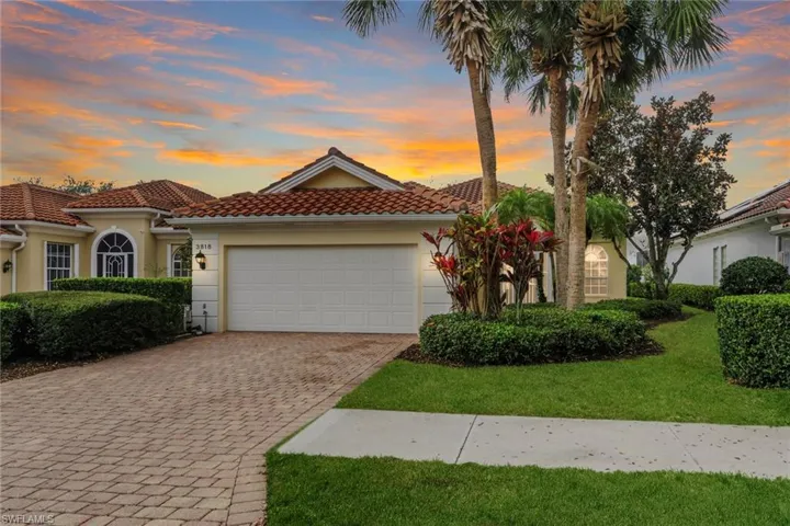 Mediterranean / spanish-style home featuring a garage, decorative driveway, stucco siding, a tile roof, and a front lawn