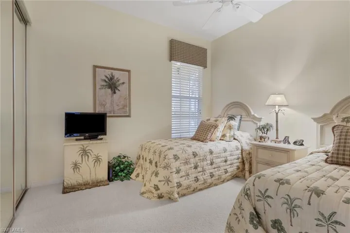 Carpeted bedroom with a closet and a ceiling fan