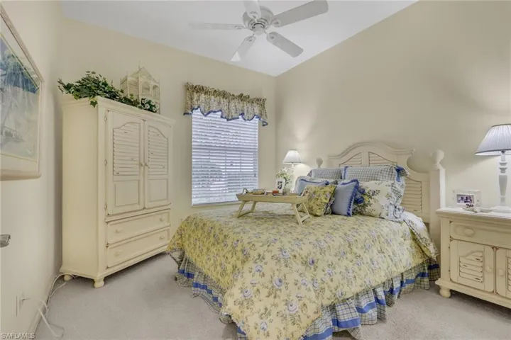 Carpeted bedroom featuring a ceiling fan