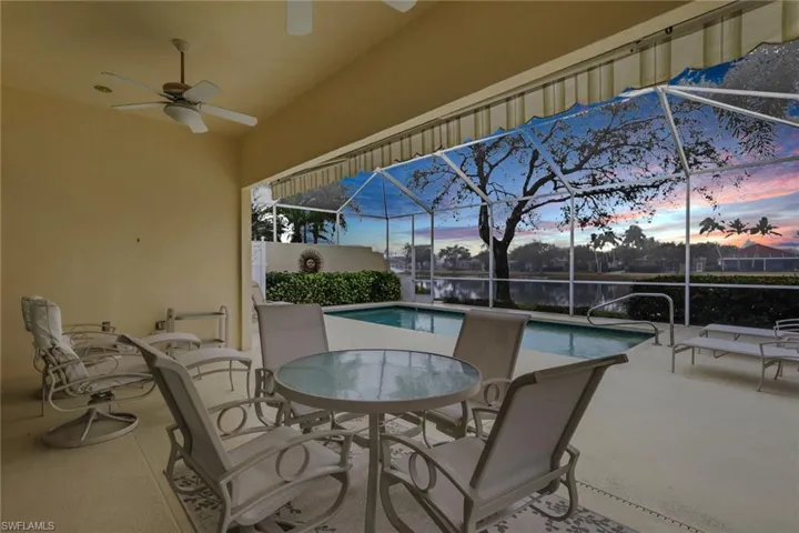 View of patio featuring a sunroom, a lanai, a ceiling fan, an outdoor pool, and outdoor dining space