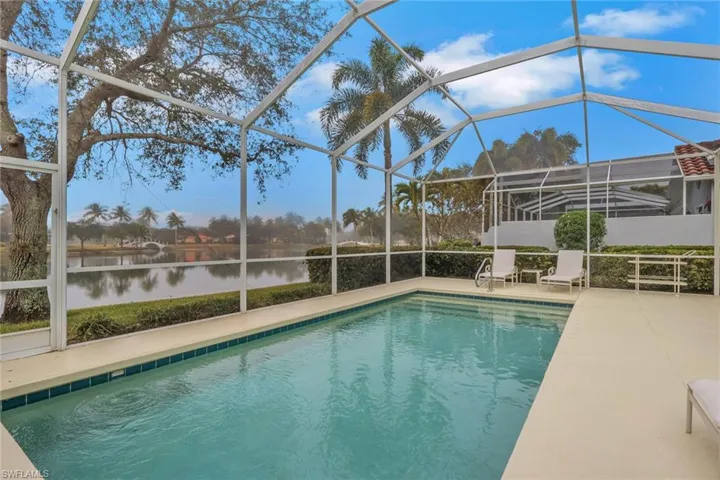 Swimming pool with a lanai, a sunroom, and a water view