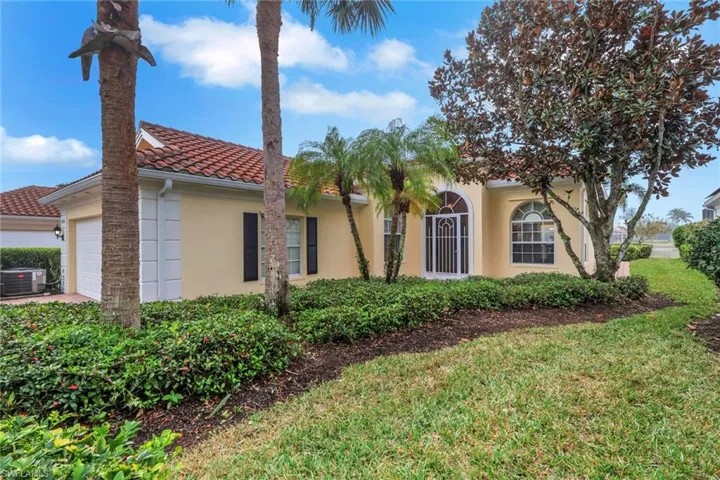 Mediterranean / spanish-style house with stucco siding, an attached garage, a front lawn, and a tile roof